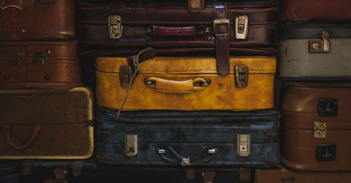 Des valises vintage empilées dans un décor rustique, illustrant le charme classique du voyage.