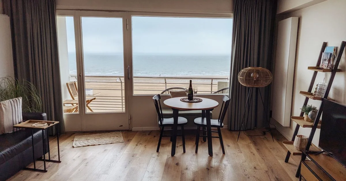 Un salon confortable dans un appartement en bord de mer avec une vue imprenable sur l'océan, doté d'une décoration moderne.