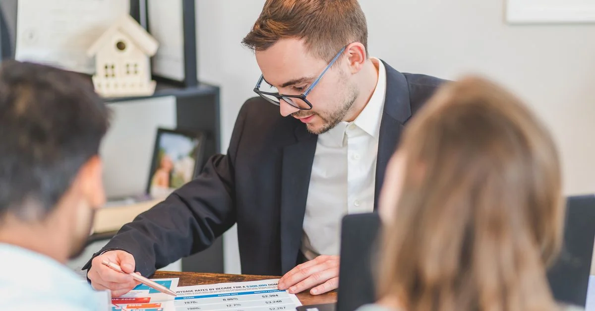 Un agent immobilier explique les options hypothécaires à des clients dans un bureau.